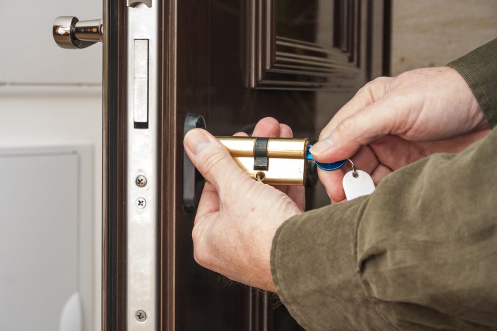 homeguide locksmith rekeying a front door lock on house